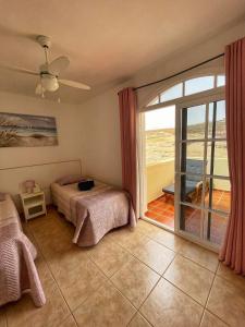 Schlafzimmer mit einem Bett und einer Glasschiebetür in der Unterkunft Villa Katerina in Caleta de Fuste