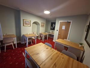 comedor con mesas y sillas de madera en Lyndon Guesthouse en Dublín