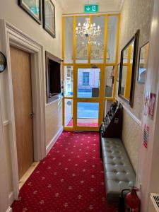 a hallway with a door and a red carpet at Lyndon Guesthouse in Dublin