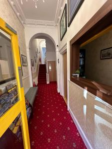 pasillo con alfombra roja y escalera en Lyndon Guesthouse en Dublín