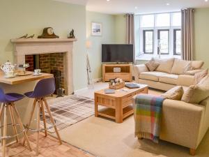 Addycombe Cottage في روثبيري: غرفة معيشة مع أريكة ومدفأة