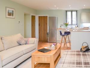 ein Wohnzimmer mit einem Sofa und einem Tisch in der Unterkunft Addycombe Cottage in Rothbury