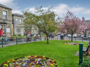 a park with flowers and trees in a city at Addycombe Cottage in Rothbury