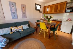 a living room with a couch and a table and a kitchen at Casa Rural Maria in Hermigua