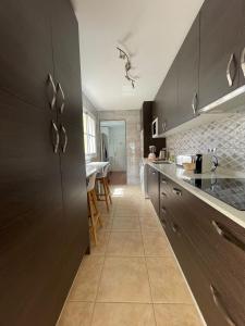 a kitchen with black cabinets and a counter top at Villa Katerina in Caleta De Fuste