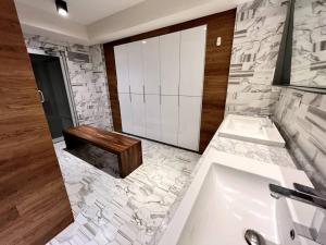 ein Badezimmer mit einer Badewanne, einem Waschbecken und einer Bank in der Unterkunft Luxury 4BR Apartment w Pool, Spa & Stunning Views in Puebla