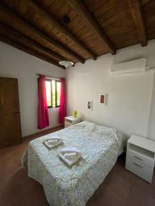 a bedroom with a bed with two towels on it at Cabaña Club Nautico Los Reyunos in San Rafael +18 photos