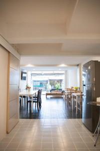 una cucina e una sala da pranzo con tavoli e sedie di Sclass HOME Private, Central old city (Wholehouse) a Chiang Mai
