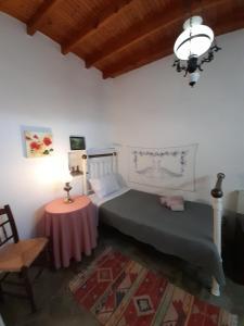 1 dormitorio con 1 cama y 1 mesa con lámpara en Paros traditional house en Episkopianá