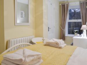 Una habitación con una cama con toallas. en Tilly Cottage, en Greenhead