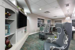 une salle d'attente avec des chaises et une télévision à écran plat dans l'établissement Residence Inn Brownsville, à Brownsville