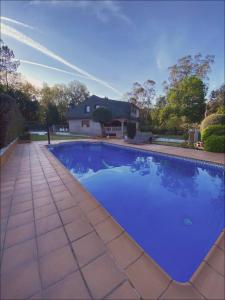 una piscina en un patio con una casa en A couquiña en Ponteareas