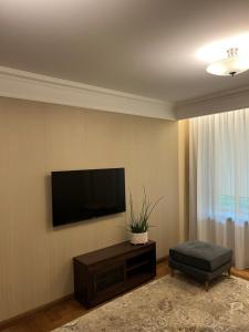 een woonkamer met een flatscreen-tv aan de muur bij 101 Large Space in Kaunas
