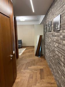 een hal met een bakstenen muur en een houten vloer bij 101 Large Space in Kaunas