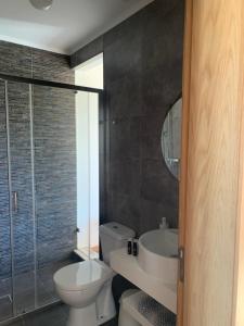 uma casa de banho com um WC, um lavatório e um espelho. em Herdade Da Maridona - Agroturismo em Estremoz