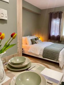 una habitación con una cama y una mesa con platos. en Chrysal Cozy Apartment en Ioánina