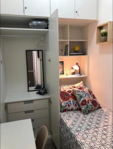 a small bedroom with a bed and a mirror at Suíte privada no melhor do Leblon in Rio de Janeiro