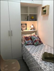 a small bedroom with a bed and a white cabinet at Suíte privada no melhor do Leblon in Rio de Janeiro
