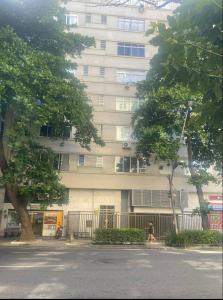 a building with a person walking in front of it at Suíte privada no melhor do Leblon in Rio de Janeiro