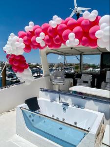 um deque com uma banheira de hidromassagem e balões num barco em COZY CONDO OCEAN 3xDECK YACHT em Brooklyn