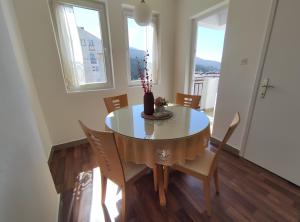 - une table à manger avec des chaises et un vase dans l'établissement Charming & Spacious 2 Bedroom Apartment with a Gorgeous 8th-floor view, à Ohrid