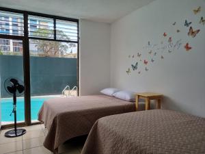 2 camas en una habitación con mariposas en la pared en Central Hostel en Guatemala
