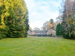 een groot huis met een grote tuin ervoor bij Ladybird Cottage in Lochend