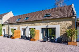 une maison avec des chaises et des plantes devant elle dans l'établissement Le noé, à Caen