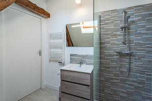 La salle de bains est pourvue d'un lavabo et d'une douche. dans l'établissement Le noé, à Caen