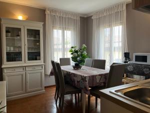 a dining room with a table with chairs and a kitchen at Anfite Apartments Aleardi in Peschiera del Garda