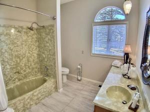 a bathroom with a tub and a sink and a toilet at Tuscan Manor in Eureka Springs