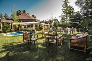 a yard with chairs and a table and a pool at Hostería Valle Verde 