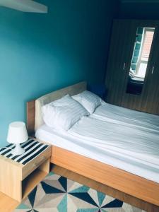 een bed in een slaapkamer met een blauwe muur bij Apartament Kilińskiego w centrum Ustki in Ustka