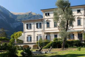 a large white building with a statue in front of it at Villa Bertoni Terrazzo - Tremezzo by LoveComo in Tremezzo