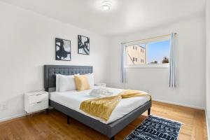 a white bedroom with a bed and a window at Cozy 2 Bedroom Home Near SFO with Private Parking in San Bruno