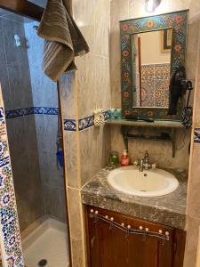 y baño con lavabo, espejo y ducha. en Appartement meublé 5 personnes en plein centre ville, en Rabat