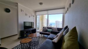 a living room with a couch and a large window at Departamento Marina Horizonte II in Coquimbo