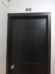 czarne drzwi z znakiem na górze w obiekcie CASA VERDE Habitaciones en Bucaramanga w mieście Bucaramanga