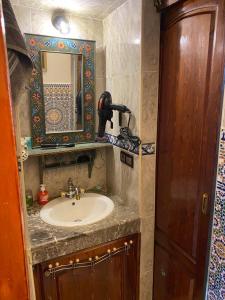 y baño con lavabo y espejo. en Appartement meublé 5 personnes en plein centre ville, en Rabat