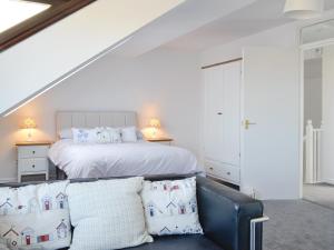 a white bedroom with a bed and a couch at Harbour Gates in Maryport