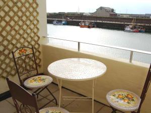 a balcony with a table and two chairs and a river at Harbour Gates in Maryport