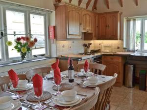 a kitchen with a table with red napkins on it at Hawthorne Cottage in Preston