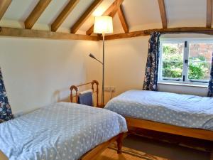 a bedroom with two beds and a window at Hawthorne Cottage in Preston