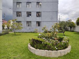 un edificio con una cama de flores frente a un edificio en Mi Casa, en Quito