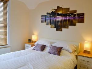 a bedroom with a white bed with two lamps at Nemo in Sandown
