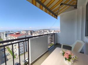 a balcony with a table and a view of a city at Charming & Spacious 2 Bedroom Apartment with a Gorgeous 8th-floor view in Ohrid