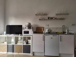 a kitchen with white cabinets and a microwave at Tranquility studio apartment in Estepona