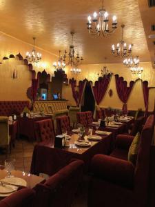een eetkamer met tafels en stoelen en kroonluchters bij Downtown Luxury furnished apartment in Jerevan