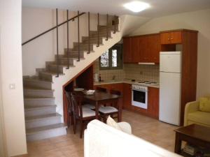 a kitchen with a staircase leading up to a living room at IRIDA VILLA in Ayia Evfimia