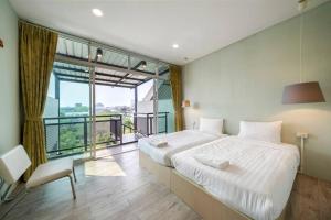 ein Schlafzimmer mit einem großen Bett und einem großen Fenster in der Unterkunft Sclass Townhome, 5 min from Night Market old city in Chiang Mai